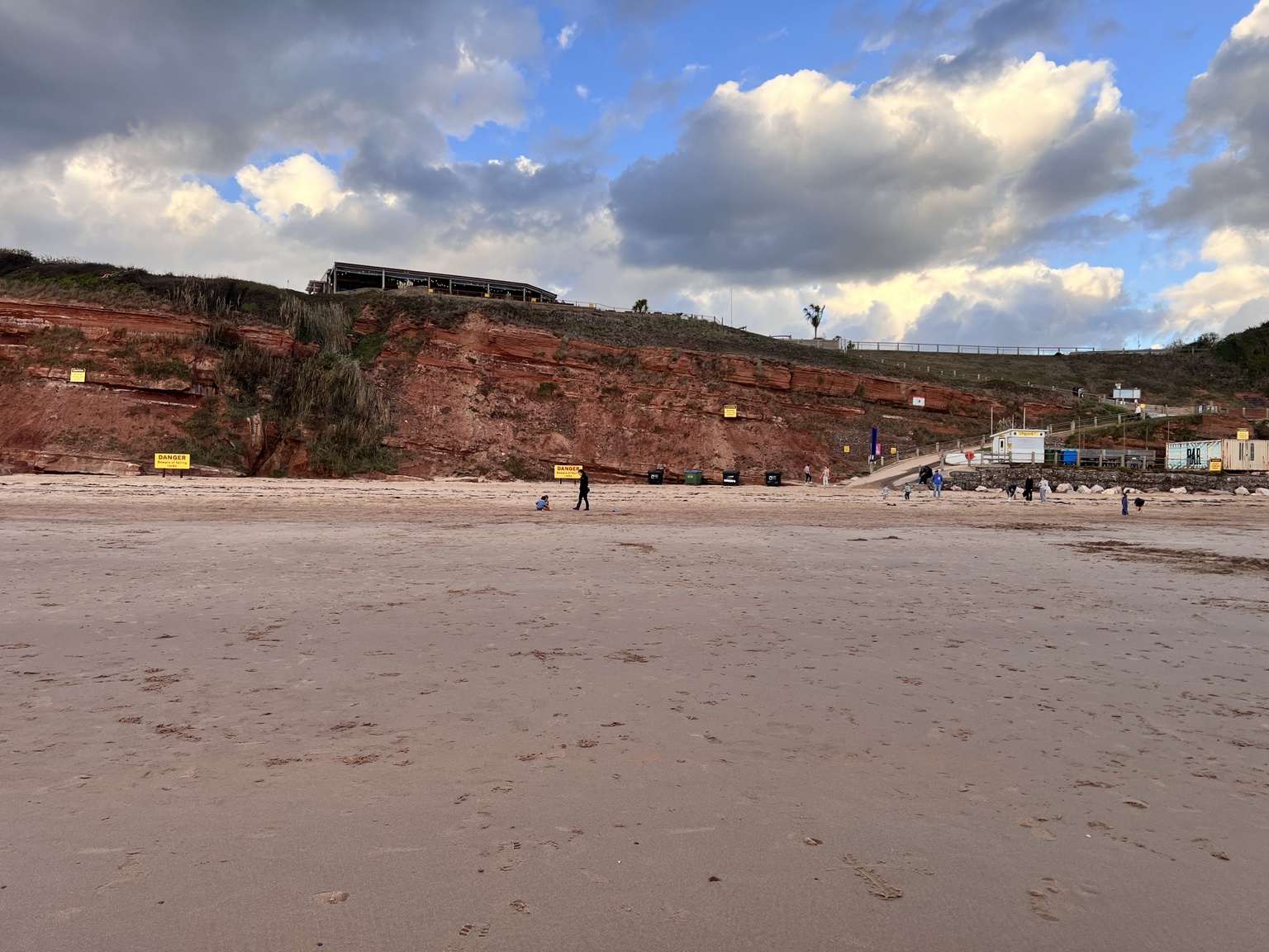 Beach and high red cliffs with the sloping path back towards Devon Cliffs holiday park